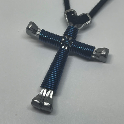 A small navy cross of nails necklace on a black cord.
